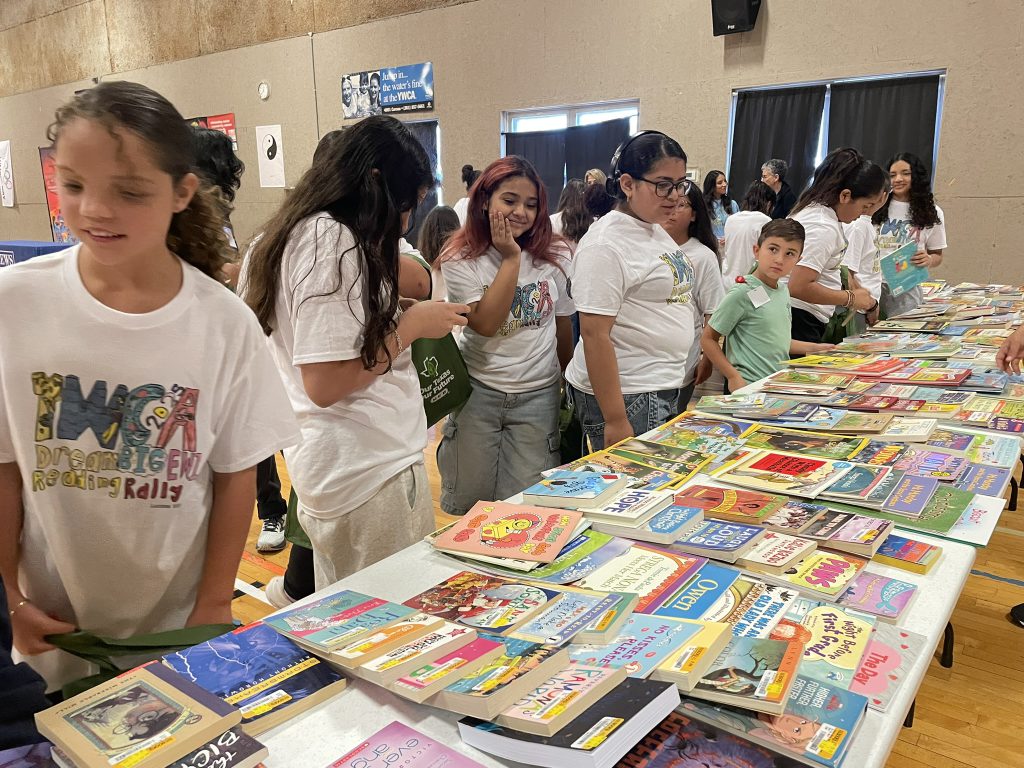 Girls picking out books at the 2025 EWI Reading Rally